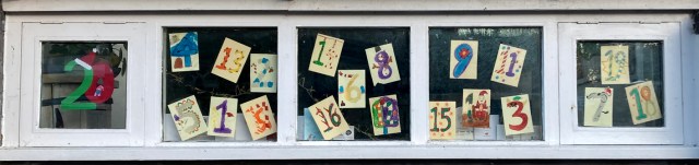 Long horizontal window decorated with coloured numbers written on pieces of paer, 1 to 20