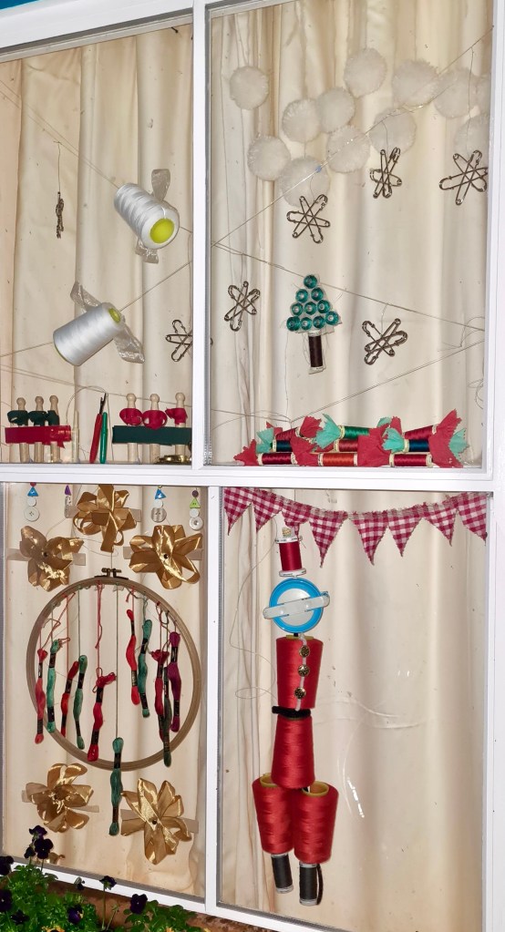 Window decorated with sewing materials in Christmas theme